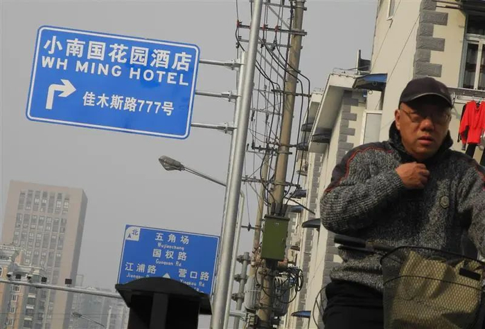 2012年的黄兴路近松花江路处，马路边横出一块指向小南国花园饭店指示牌。肖允摄
