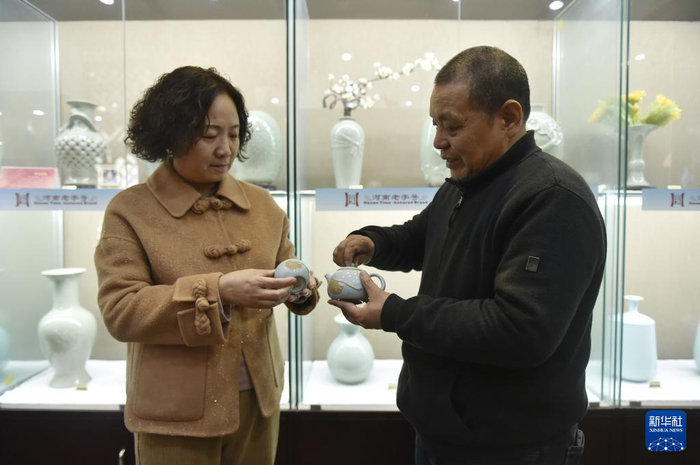   1月10日，范随州（右）和王振芳在汝州市弘宝汝窑展厅交流共同研发的汝瓷作品。新华社记者 鲁鹏 摄