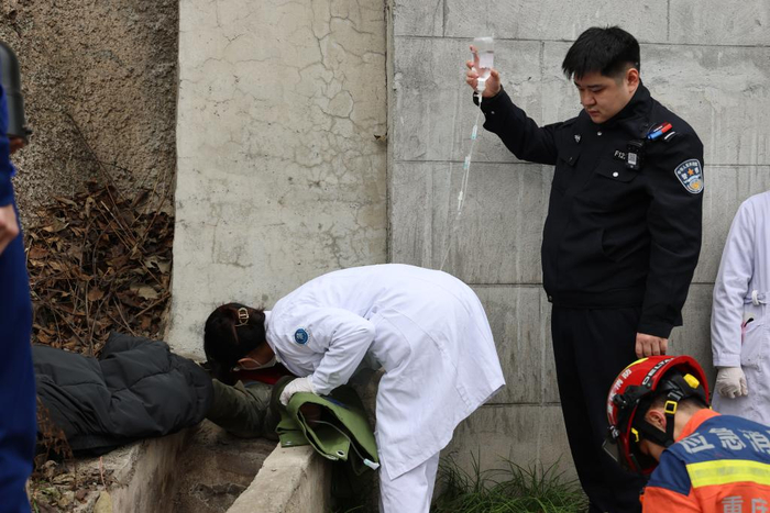 辅警张根源为男孩举点滴。鱼洞派出所供图