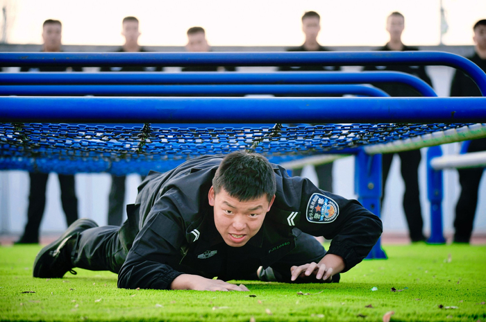 时至三九,地面温度早已低于冰点,队员们匍匐前进通过地网.