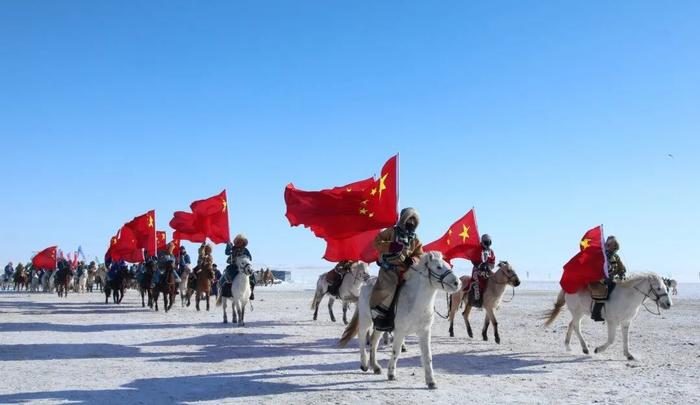 五星紅旗迎風飄揚燃起篝火,拉起馬頭琴牧民,遊客身著民族服飾手拉手圍