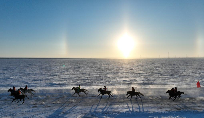 2023年12月17日，选手在内蒙古自治区第二十届冰雪那达慕耐力赛马比赛中（无人机照片）。新华社记者贝赫摄