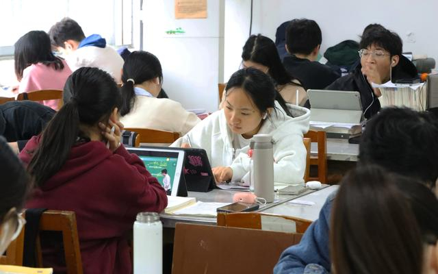 ▲资料图：高校学生用电子设备看书学习。图/新华社