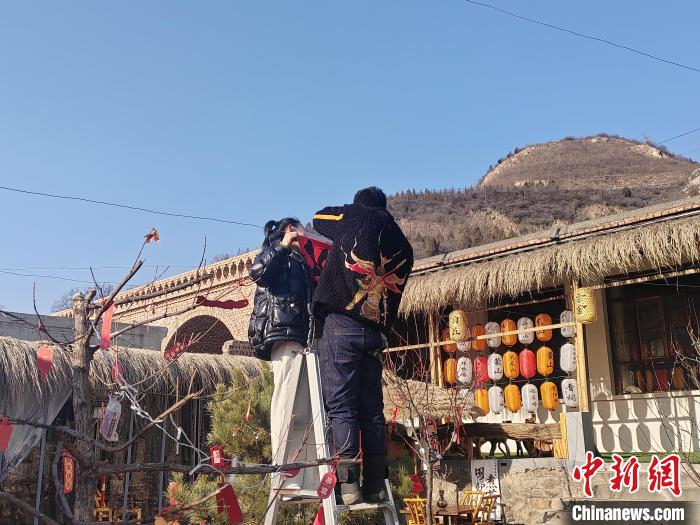 1月10日，店头古堡景区内闲置房舍出租改造兴起浪潮，村里经营茶馆的一对年轻夫妻正在为小院添加春节装饰物。高雨晴 摄
