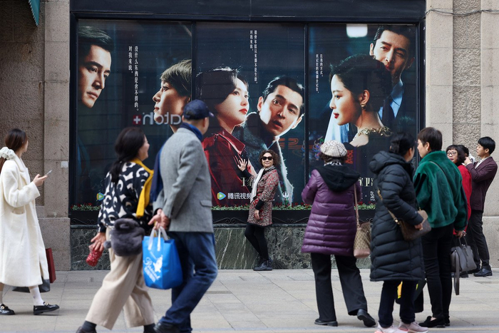 （和平饭店门口，诸多游客在《繁花》海报前拍照留念）