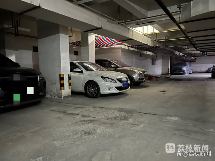 重走案发现场，左边黑色轿车位置为张伟原本租的停车位，案发当日他出库左转，将妻子卷入车底。