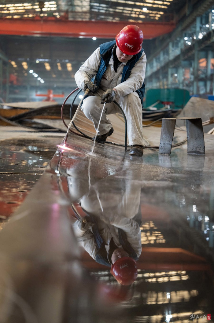 火工对船身零部件进行水火弯板施工。本报记者 孟雨涵 摄