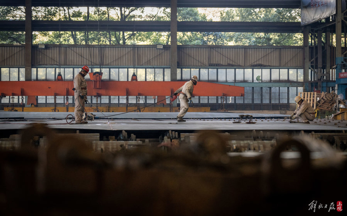 江南造船制造二部车间内，火工、电焊、打磨正在交叉作业。本报记者 孟雨涵 摄