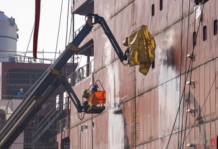 对船体上建外板进行火工矫正。本报记者 孟雨涵 摄