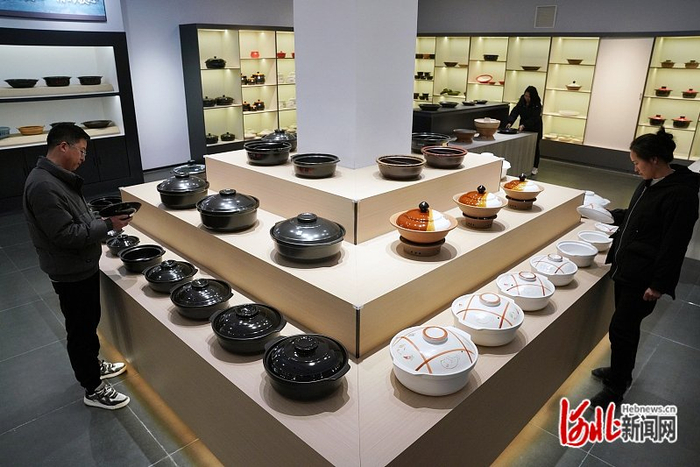 1月3日，邯郸市峰峰矿区河北煲仔王陶瓷有限公司产品展厅内，顾客在了解、选购砂锅产品。河北日报通讯员 李 栋摄