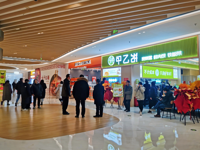 在工作日的午餐时段，地下1层的几家中式快餐店需要等位。
