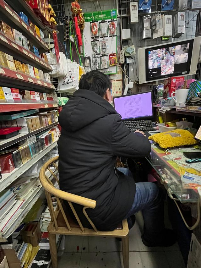 王计兵用小卖部的电脑上网。空闲时，他也在这里整录诗歌。 新京报记者 冯雨昕 摄