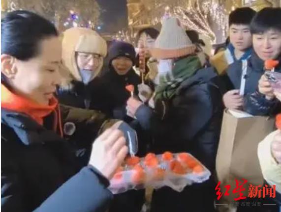 ▲丹东市文旅局局长徐敏在中央大街给外地游客发丹东草莓。图据丹东发布