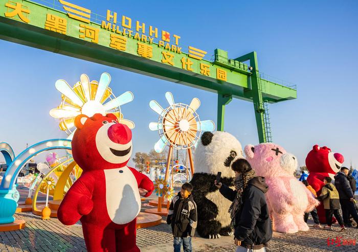 ▲1月12日，游客在第三届呼和浩特欢乐冰雪节活动现场与卡通人偶互动。图据视觉中国