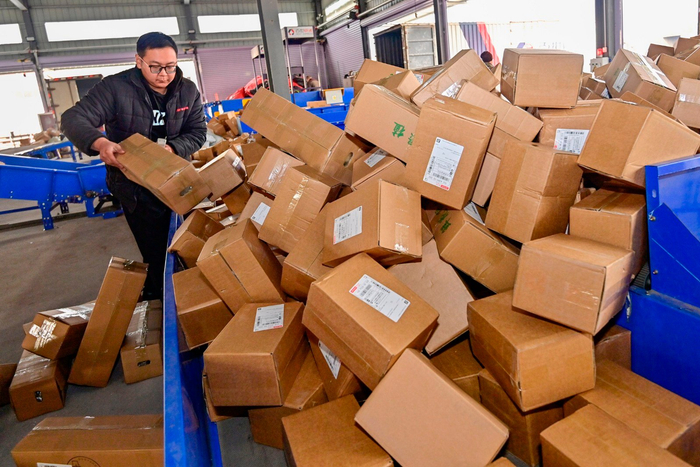 山东省青州市一家快递公司的工作人员在分拣快递包裹。（图片由CNSPHOTO提供）