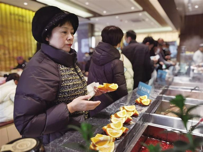     市民在筷上瘾门店品尝赣南脐橙