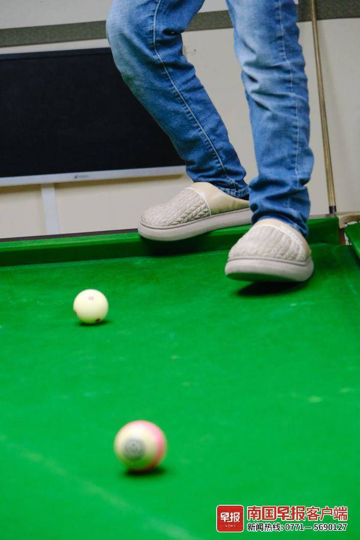 ▲用脚打台球是黄李的一项技能。