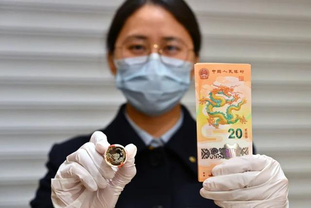 1月9日，中国建设银行北京兴融支行的工作人员展示2024年贺岁双色铜合金纪念币和纪念钞。新华社记者 李鑫 摄