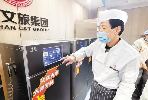     1月10日，在文旅·云餐唐钢社区食堂，厨师薄艳成操作炒菜机器人进行“一键式”炒菜。河北日报记者 王育民摄