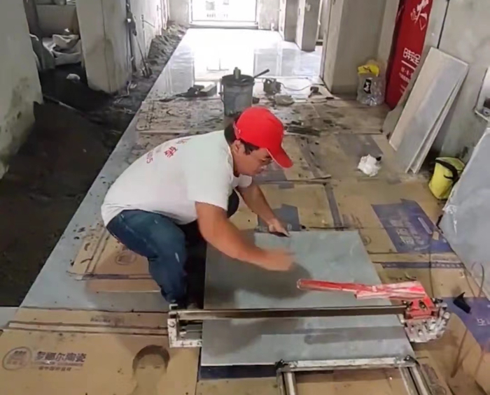 ▲吴先生正在用切砖机修改砖块尺寸。图据受访者