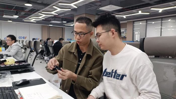 △ 伍世荣正与同事探讨。赖英娜 摄