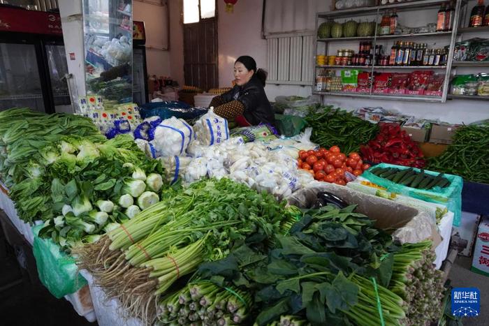  1月17日，在甘肃省临夏州积石山县，一名蔬菜店经营者在整理蔬菜。新华社记者 马希平 摄