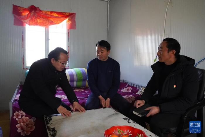   1月17日，在宋家沟村安置点的板房内，乡镇干部（左）和村干部（右）入户倾听村民建议。新华社记者 马希平 摄