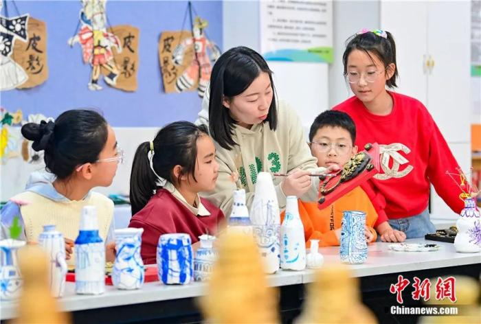 鄂托克前旗第二小学泥塑社团教师指导学生学习泥塑制作技艺。王正 摄