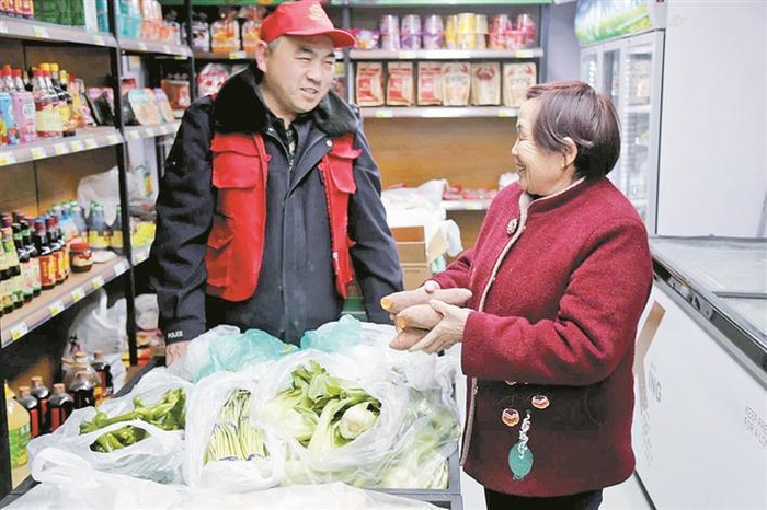     1月16日，在一师阿拉尔市供销疆源公司的一家直营店里，售货员给顾客介绍蔬菜品种和价格。董冰玉  摄