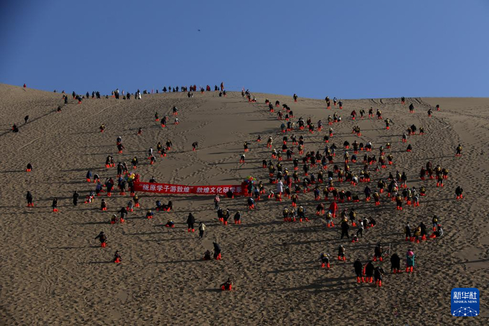 1月16日，研学团队学员在甘肃省敦煌市鸣沙山月牙泉景区开展登山比赛。新华社发（张晓亮 摄）