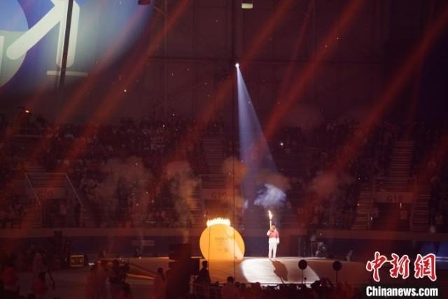 图为李净玟点燃圆形主火炬。中新社记者 刘旭 摄