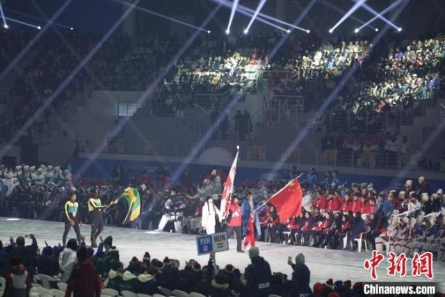 图为中国女子冰球运动员张菁月高举五星红旗入场。中新社记者 刘旭 摄