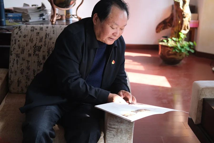 杨稚明翻看工厂25周年时做的纪念册