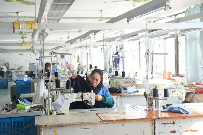 稚信服装厂的车间，仍保留着90年代时期的样式，纺织女工在加工布料
