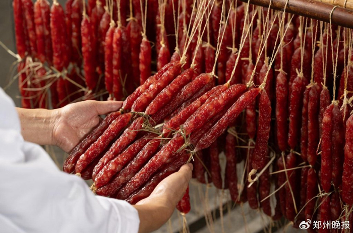 何发坤在检查腊肠烘烤情况（广东珠江桥供图）