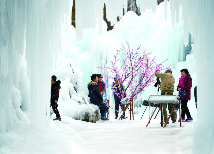 　　市民在沕沕水冰瀑美景前拍照留影。本报记者 张晓峰 摄