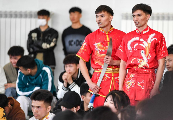 ↑2023年4月20日，新疆昌吉学院学生阿布都拉·巴吐尔江（右一）和弟弟阿布都热合曼·巴吐尔江（右二）一起观赛。