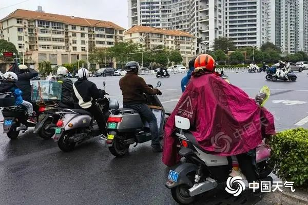 △广西南宁昨日寒风冷雨来袭，市民厚装出行。（图/曾海科）