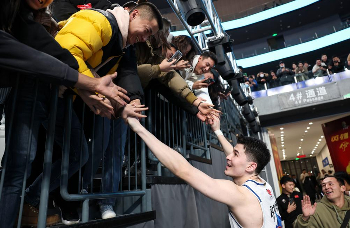 ↑2023年12月11日，一场CBA常规赛后，新疆伊力特队球员阿不都沙拉木与球迷互动。