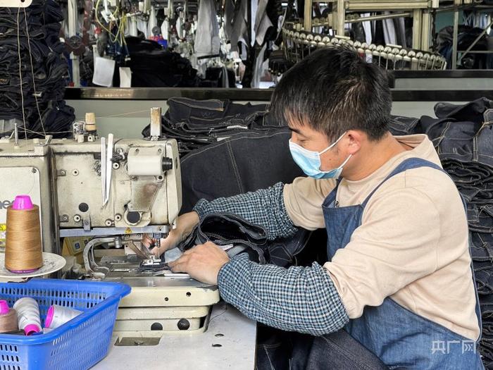 工人正在缝制牛仔裤（央广网记者 官文清 摄）