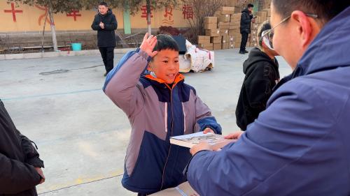 （图：积石山县受灾地区学生接受图书捐赠。）