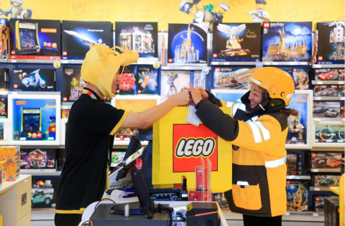 ▲ 美团骑手在乐高授权专卖店取货