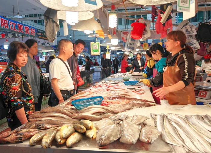 闸坡农贸市场，游客购买海鲜。梁文栋 摄