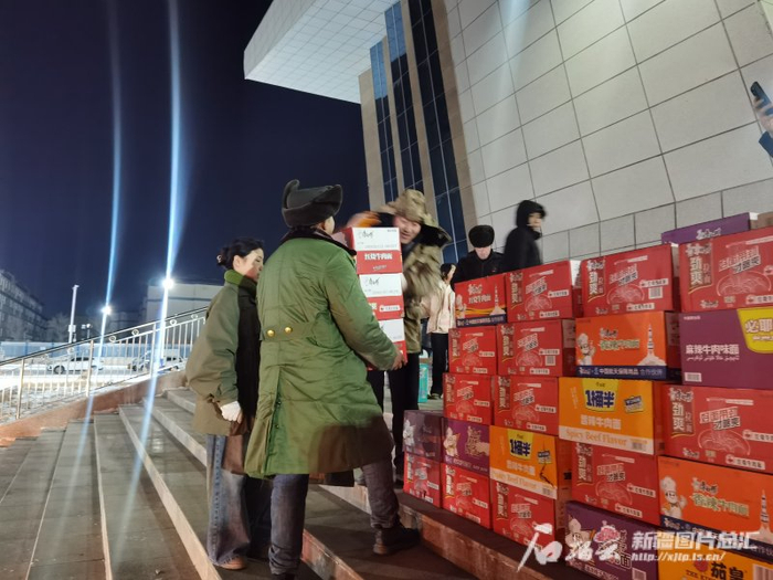 阿合奇县科技文化体育中心安置点里，志愿者正在分发物资。石榴云/新疆日报 记者 刘萌萌摄