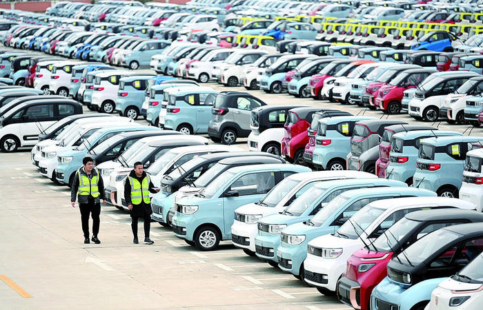     工作人员检查准备外运的新能源汽车