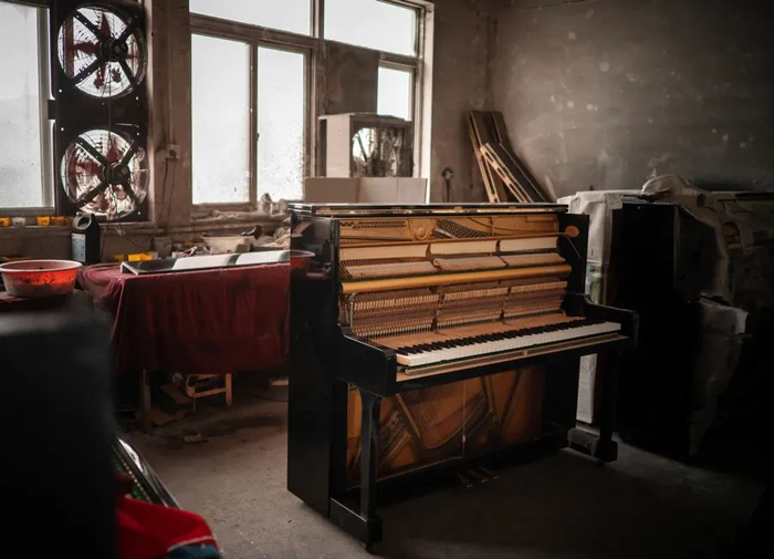 厂房里，一台正在被翻新的二手钢琴