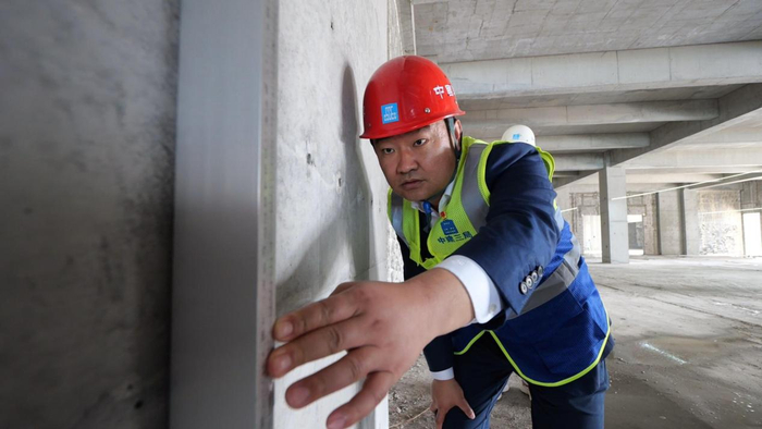 图为"建证亮丽北疆"的马泉在施工现场进行测量.(资料图)