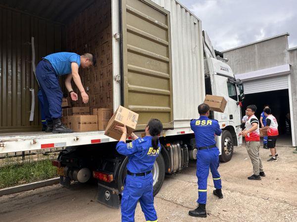 图：盐津铺子员工与浏阳市蓝天救援队在吉林榆树搬运捐赠物资