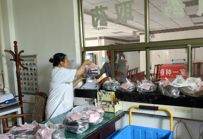 2023年6月20日，山东省聊城市东阿县刘集中心卫生院工作人员在分发中药汤包。新华社记者张力元 摄
