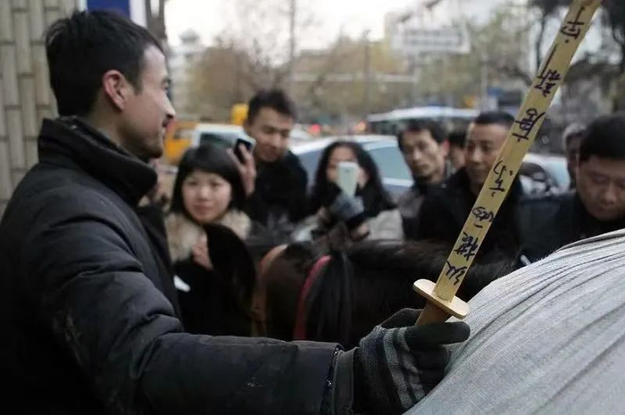 十年前“骑马哥”带一柄写着“纵横两京唐新宇”的短剑骑马从北京到南京。受访者供图